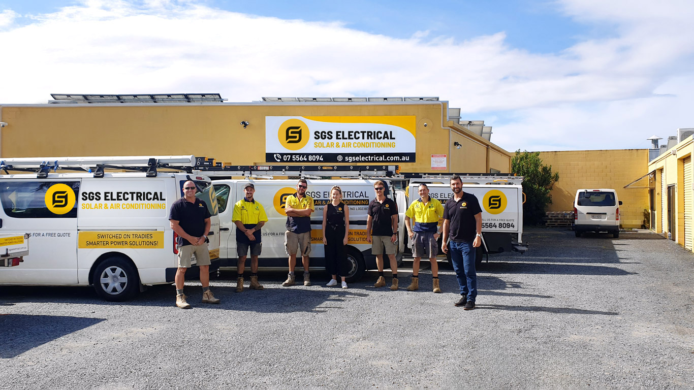 The SGS Electrical team standing in front of their branded vans at the Ashmore depot
